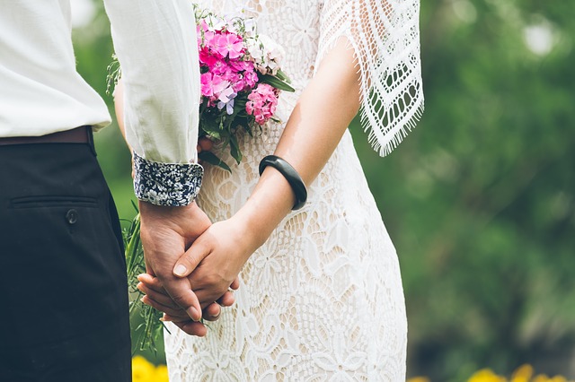 nevěsta a ženich se drží za ruce